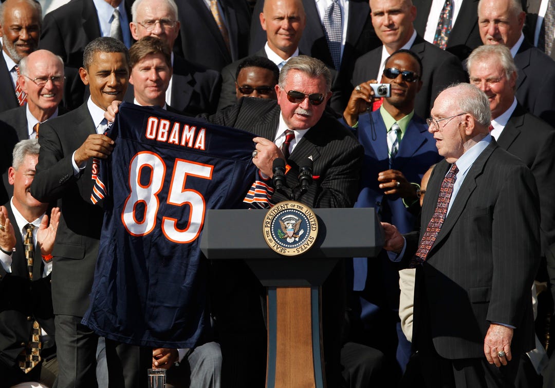 U.S. President Barack Obama (L) is presented with a jersey by 1985 Chicago Bears Coach Mike Ditka as Defensive Co-Ordinator Buddy Ryan watches on as Obama honors the Super Bowl-winning Chicago Bears NFL team on the South Lawn of the White House in Washington, October 7, 2011. In 1986, the team's White House reception was cancelled due to the Space Shuttle Challenger tragedy.