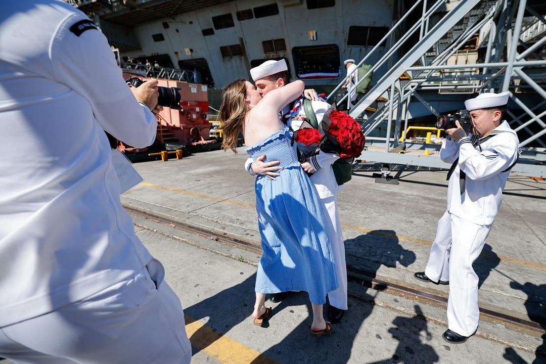 A sailor kisses his partner after the US Navy Nimitz-class aircraft carrier USS Abraham Lincoln returned home following an extended deployment in the Middle East at Naval Base Coronado in San Diego, California, U.S., October 8, 2026. REUTERS/Mike Blake